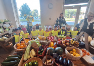 Dzieci stoją w warzywaniaku przed stoiskiem