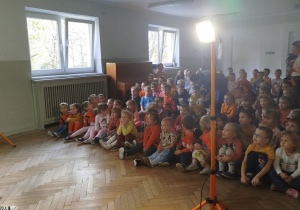 Dzieci siedzą na widowni i słuchają wprowadzenia do bajki