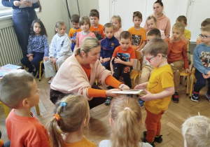 Nauczycielka wręcza dziecku dyplom