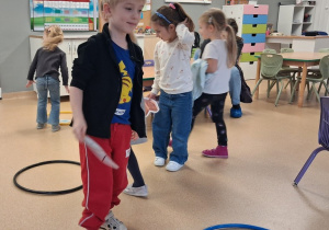 Dzieci segregują śmieci do odpowiednich kółek - koszy na śmieci