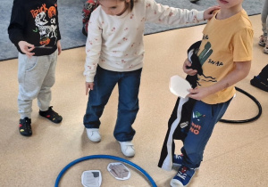 Dzieci segregują śmieci do odpowiednich kółek - koszy na śmieci