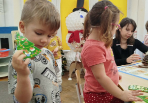 Chłopczyk pokazuje udekorowaną przez siebie choinkę