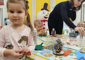 Dziewczynka pokazuje zrobioną przez siebie ozdobę