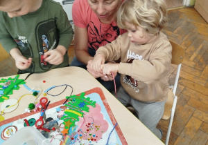 Dziecko wspólnie z mamą tworzą piękną ozdobę świąteczną