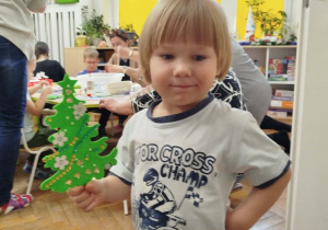 Chłopczyk z udekorowaną przez siebie choinką