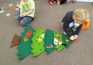 Dziewczynka przyczepia gwiazdę na górę choinki