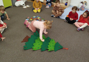 Dziewczynka przyczepia element na choinkę