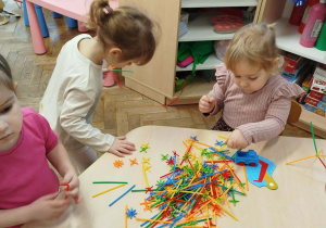 Dziewczynki układają konstrukcje z cienkich patyczków