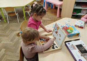 Dziewczynki tworzą obrazy na magnetyczne tablicy