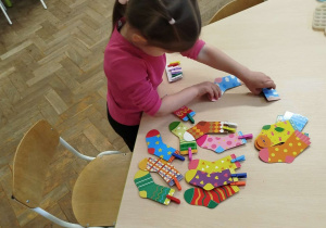 Dziewczynka układa na stole skarpetki w pary