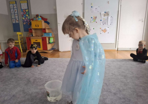 Studnia życzeń - dzieci wrzycają grosik z życzeniem do wody