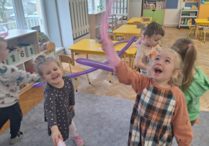 Dzieci bawią się i tańczą z długimi balonami