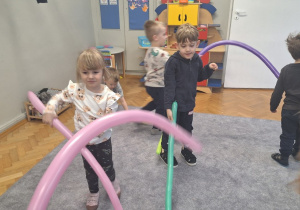 Dzieci bawią się i tańczą z długimi balonami