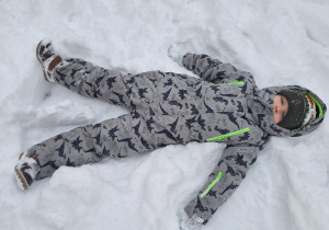 Dzieci robią aniołki na śniegu