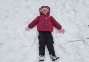 Dzieci robią aniołki na śniegu