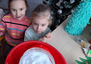 Dzieci obserwują przyniesiony z ogrodu snieg