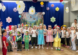 Dzieci z opaskami na głowach zwierzątek - żaby, biedronki, motylki i zajączki występują w przedstawieniu wiosennym