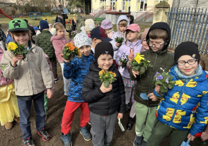 W ogrodzie przedszkolnym dzieci pokazuja wybrane dla siebie bratki