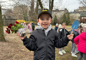 Chłopiec pokazuje wybrane bratki, które posadzi na górce