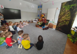 Dzieci słuchają informacji o mrówkach i oglądają pokazywane zdjęcia dotyczące mrówek