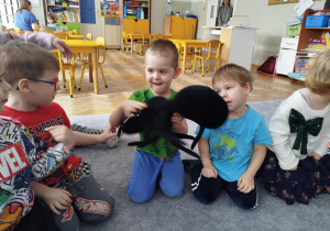 Dzieci oglądają dużą maskotkę mrówki