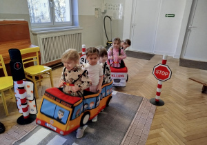 Dzieci w makietach pojazdów wcielają się w rolę kierowców i pasażerów