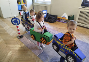 Dzieci w makietach pojazdów wcielają się w rolę kierowców i pasażerów
