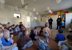 Przedszkolaki siedzą i uczestniczą w rozmowie na temat bezpieczeństwa