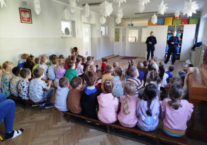 Przedszkolaki siedzą i uczestniczą w rozmowie na temat bezpieczeństwa