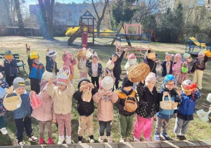 Zając Wielkanocny sprawdza czy każdy jest przygotowany na zbieranie jajek, a dzieci pokazują koszyczki