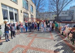 Zając Wielkanocny sprawdza czy każdy jest przygotowany na zbieranie jajek, a dzieci pokazują koszyczki