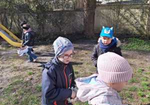 Dzieci zbierają jajeczka do swoich koszyczków