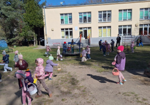 Dzieci zbierają jajeczka do swoich koszyczków