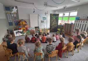 Dzieci siedzą i czekają na rozpoczęcie zajęć