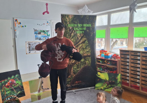 Prowadzący opowiada dzieciom i mrówkach wykorzystując duże maskotki