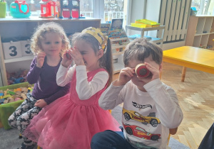 Dzieci patrzą przez szkiełka, które zmieniają obraz na taki jak widzą mrówki