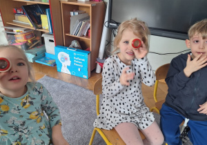 Dzieci patrzą przez szkiełka, które zmieniają obraz na taki jak widzą mrówki