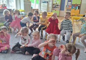 Dzieci patrzą przez szkiełka, które zmieniają obraz na taki jak widzą mrówki