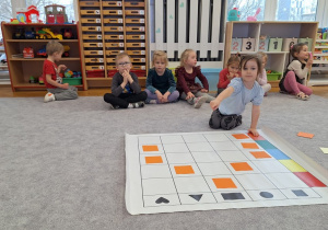 Dzieci układają karmnik na macie do kodowania wg kodu z tablicy