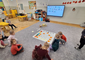 Dzieci układają karmnik na macie do kodowania wg kodu z tablicy