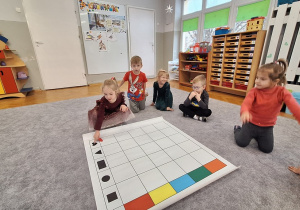 Dzieci układają karmnik na macie do kodowania wg kodu z tablicy