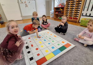 Dzieci układają karmnik na macie do kodowania wg kodu z tablicy