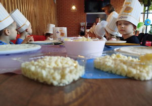 Dzieci słuchają Pani opowiadającej ciekawostki o pizzy