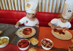 Dzieci komponują swoją pizzę - układają na cieście wybrane przez siebie składniki