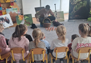 Prowadzący opowiada dzieciom o mrówkach, wykorzystując duże maskotki