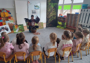 Prowadzący opowiada dzieciom o mrówkach, wykorzystując duże maskotki