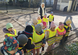 Dzieci zaglądają do ogródka pod blokiem wypatrując kiełkujących wiosennych roślin