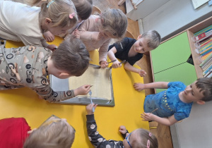 Dzieci nakłuwają widelcem ciasto pizzy
