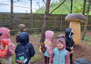 Dzieci z przewodnikiem zwiedzają wystawę rzeźb owadów, mikroorganizmów i grzybów