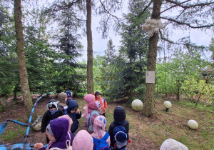 Dzieci z przewodnikiem zwiedzają wystawę rzeźb owadów, mikroorganizmów i grzybów